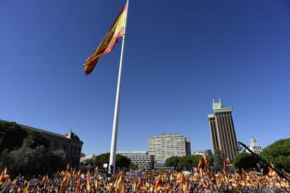 La bandera gigante de España, situada en la plaza de Colón, ondea durante la concentración.