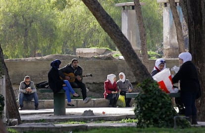 Un hombre toca la guitarra para una mujer en un concurrido parque de Damasco, el pasado 13 de febrero. En este ambiente resulta difícil creer que a varios kilómetros de distancia se puede ver la cara más cruda de una guerra.
