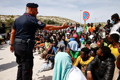 Un 'carabiniere' hablaba el 16 de septiembre a un grupo de migrantes llegados a la isla italiana de Lampedusa.