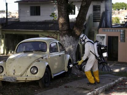 Um trabalhador fumiga um carro, ontem no Brasil.