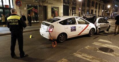 Un policía municipal observa el taxi siniestrado el pasado domingo.