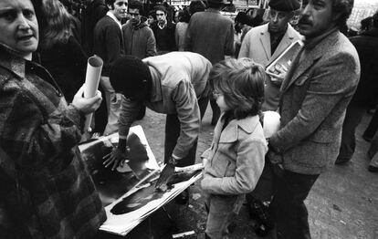 Un vendedor muestra la fotografía de Ernesto Guevara realizada por Alberto Korda a posibles compradores como el actor Manolo Zarzo (derecha). En la Transición el Rastro madrileño no solo era un lugar donde comprar objetos de segunda mano. Al lado del comercio habitual surgieron puestos con libros prohibidos por la censura, revistas eróticas y de confesiones religiosas no católicas.