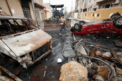 Personal de la Policía Federal iraquí camina entre varios vehículos calcinados mientras continúa la batalla contra los combatientes del Estado islámico, en la ciudad de Mosul, Irak.