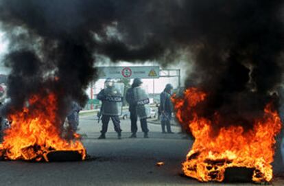 La policía protege uno de los puentes de acceso al centro de Buenos Aires detrás de la barricada de los huelguistas.