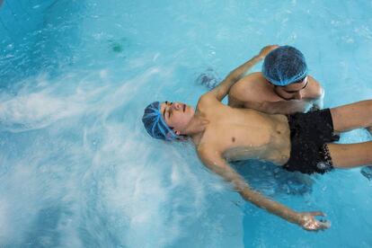 Nabih Bazih, de 14 años, en una piscina de rehabilitación tras perder la movilidad en la parte izquierda de su cuerpo.