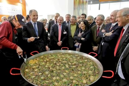 El presidente valenciano, Francisco Camps, prueba una paella durante su visita, ayer, a la feria Fruit Logística de Berlín.