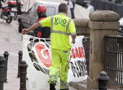 Operarios del ayuntamiento, escoltados por la Ertzaintza, retiran carteles de apoyo a ETA en las calles de Vitoria