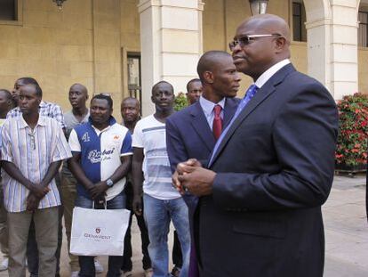 El ministro de Exteriores de Senegal, Alioune Badara Ciss&eacute;, ante el Ayuntamiento de Alicante, junto a inmigrantes de su pa&iacute;s.