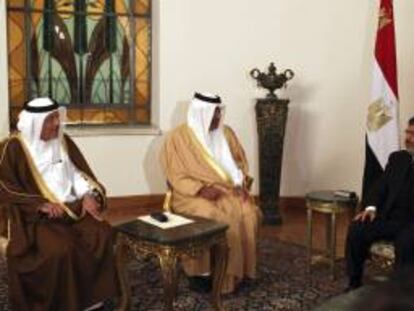 El presidente de Egipto, Mohamed Morsi (d), habla con el primer ministro de Catar, Hamad Bin Jabir Al Thani (c), y el ministro de Finanzas de Catar, Yousef Hussain Kamal (i), en el palacio presidencial de El Cairo, Egipto hoy, martes 8 de enero de 2013. Hamad Bin Jabir Al Thani confirmó que seguirá prestando dinero a Egipto para contener la crisis de divisas egipcia.