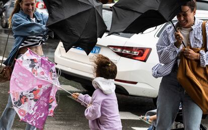 Varias personas tratan de dominar sus paraguas en San Sebastián.