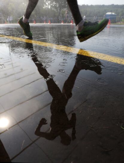 Imagen reflejada de un atleta bajo la lluvia durante la final de 50km marcha.