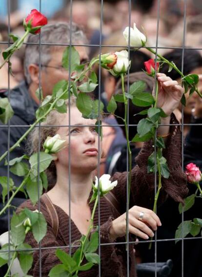 Una mujer coloca una rosa en el lugar de los atentados del pasado viernes, en Oslo