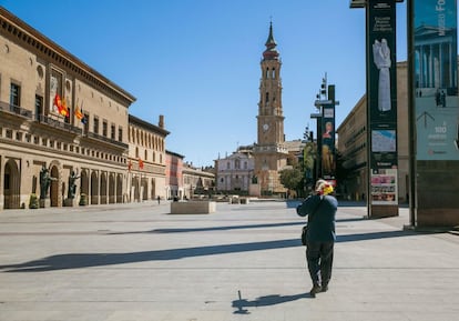 Un hombre tocaba la armónica con un altavoz en la Plaza el Pilar de Zaragoza, despoblada de visitantes el pasado sábado, en el primer día del estado de alarma decretado por el Gobierno para intentar frenar el avance del contagio por el coronavirus. Imagen tomada el 14 de marzo.