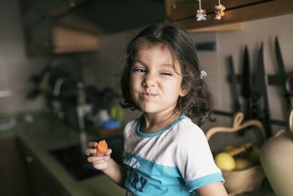 Una niña disfruta de una zanahoria. 