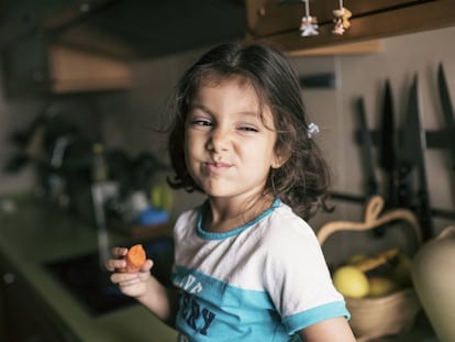 Una niña disfruta de una zanahoria. 