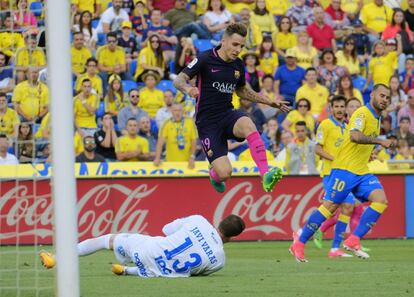 El defensa francés del Barcelona Lucas Digne salta ante el portero de Las Palmas Javi Varas durante el partido.