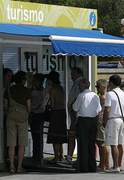 Un grupo de visitantes hace cola ante una oficina de turismo en San Sebastián.