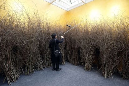 Un visitante mira una obra de arte del artista italiano Mario Merz con el título 'Son en cercle, arbres en cercle' en el Gran Palais de París.