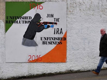 Un hombre en Londonderry (Irlanda del Norte) junto a un mural que exalta al Nuevo IRA.