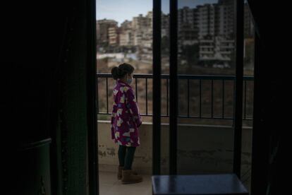 La hija de Omar se asoma por el balcón de su casa. Tiene 10 años y tarda una hora en llegar a la escuela. Unicef realizó un estudio en Trípoli y comprobó que el 63% de los menores de edad encuestados se iniciaron en el mundo laboral en los últimos tres años, en los que presenciaron la revolución, la covid-19 y una crisis económica sin precedentes.
