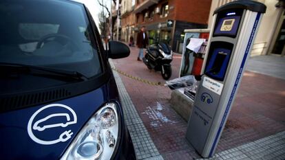 Un vehículo eléctrico enchufado a un punto de carga en el centro de Madrid.