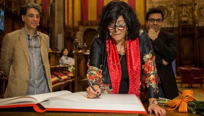 Almudena Grandes, firmando en el Saló de Cent, flanqueada por Antonio Iturbe (izquierda) y Gerardo Pisarello.