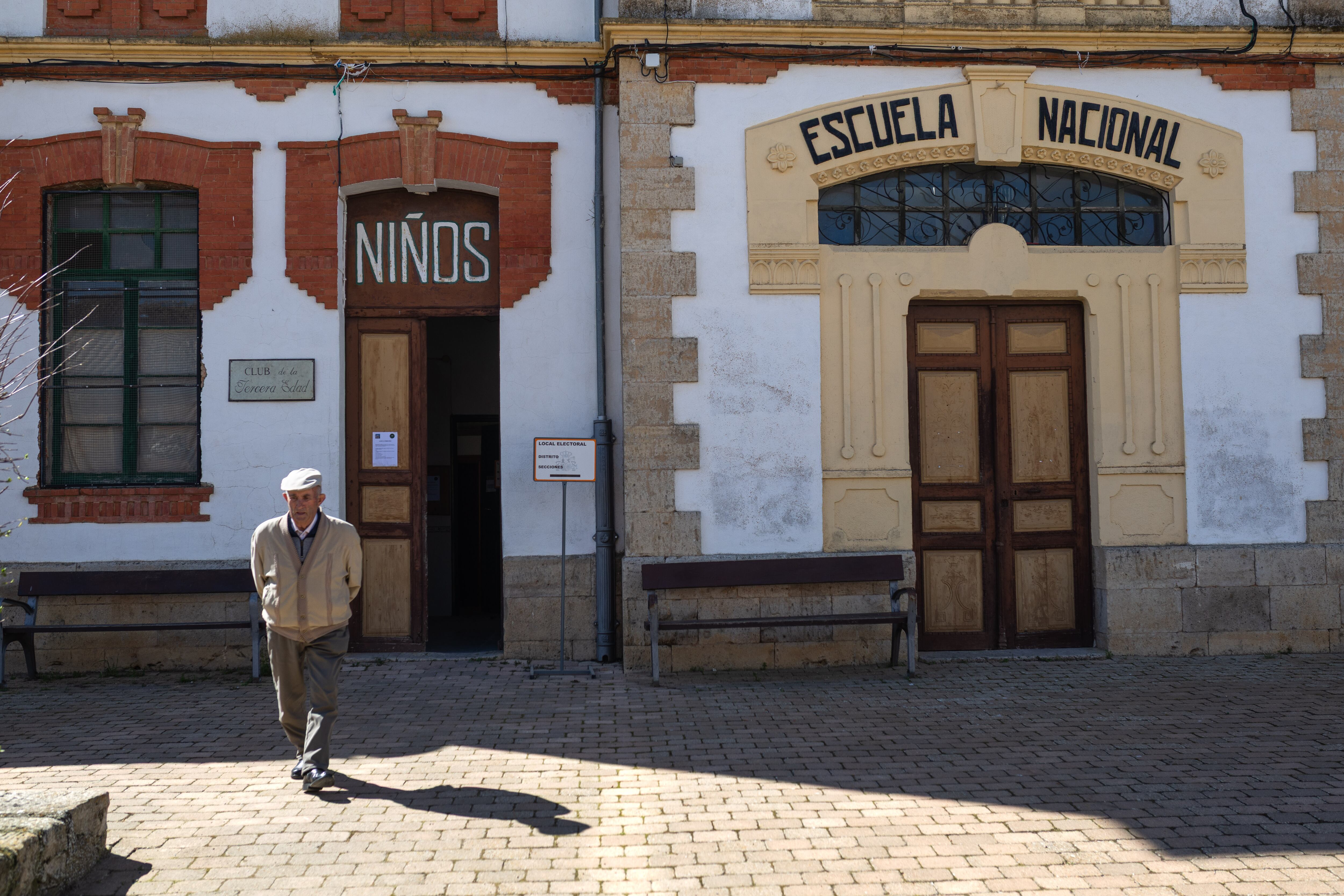 Un hombre sale de votar del colegio electoral de Pozoantiguo, ubicado en las antiguas escuelas del pueblo.