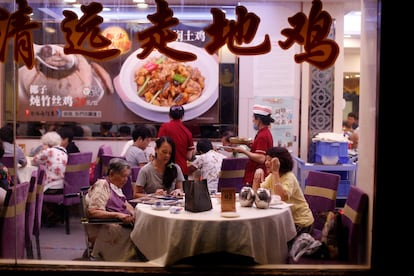Una familia se sienta a cenar en un restaurante local en el distrito de Liwan en Guanghzou (China).