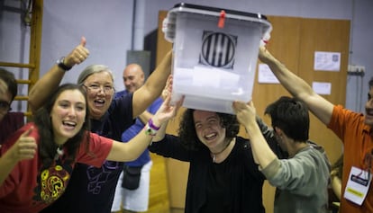 Voluntarios sostienen una urna llena de votos durante el 1-0. 