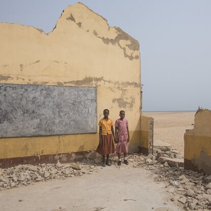 En Dzita (Ghana), dos chicas en edad escolar posan ante las ruinas de su colegio. Hace dos años la escuela primaria de la localidad perdió uno de sus cuatro edificios por la erosión costal durante la época de lluvias. Se quedaron sin cuatro aulas, forzando a la dirección a combinar los horarios de las clases para poder atender a los 670 estudiantes.