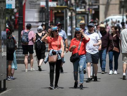 Dos mujeres intentan protegerse del sol en una céntrica calle de Barcelona el pasado noviembre durante una ola de calor.
