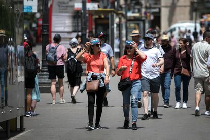 Además de mucho sol, la sensación de calor se incrementa por la abundante calima, fruto de la llegada de polvo en suspensión en la masa de aire africano muy cálido que está contribuyendo a estas altísimas temperaturas, junto a la estabilidad atmosférica. En la imagen, dos mujeres se protegen del sol en una calle céntrica de Barcelona, en el tercer día consecutivo de ola de calor.