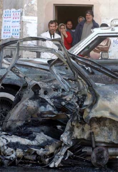 Unos iraquíes miran el coche destrozado de un suicida ayer en Bagdad.