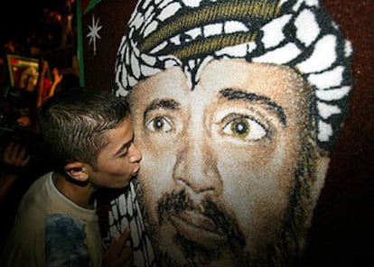 Un niño palestino besa un cartel con la imagen de Arafat.