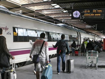 Un grupo de viajeros accede a un AVE en la estaci&oacute;n madrile&ntilde;a Puerta de Atocha.
