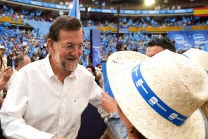 Mariano Rajoy saluda a una simpatizante, en el mitin del PP en Zaragoza.