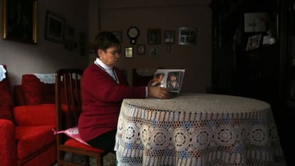 Benedicta García looks at photos of her daughter Pilar at home in Logroño.