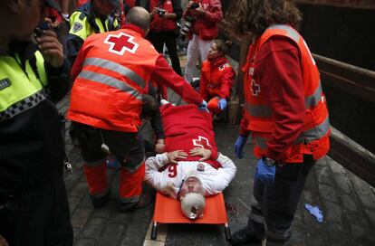 Un mozo es atendido por los servicios de emergencias durante el séptimo encierro de los sanfermines 2016.