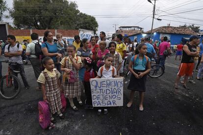Un grupo de escolares de Ureña (Venezuela) que van a la escuela en el lado colombiano, portan un letrero en el que se puede leer "Queremos estudiar, déjenos pasar" a su paso por el puente Tienditas, cerrrado en Ureña por las autoridades venezolanas.