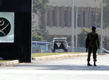 Militares paquistaníes en la puerta del cuartel de Rawalpindi. Al fondo, la camioneta blanca con la que los terroristas atacaron la guarnición.