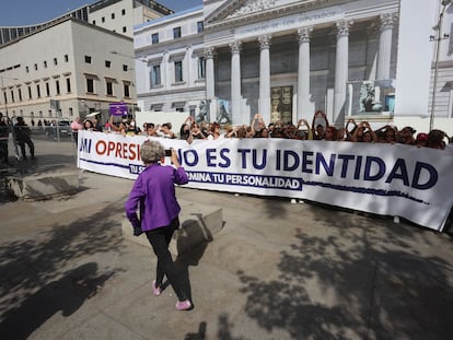 Mujeres del Movimiento Feminista de Madrid sostienen una pancarta y protestan contra la ley trans frente al Congreso de los Diputados, en Madrid.