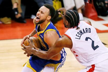 El jugador de Golden State Warriors Stephen Curry entra a canasta ante la oposición del jugador de Toronto Raptors Kawhi Leonard.