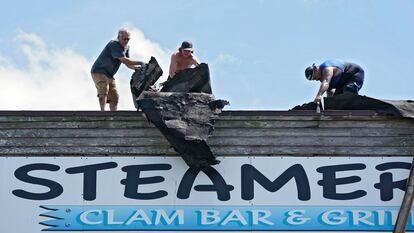 Trabajadores del restaurante Steamers de Ceday Key (Florida), el jueves, retiraban parte del techo dañado. 