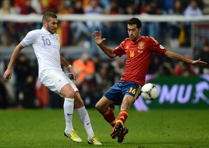Busquets intenta arrebatar el balón a Benzema.