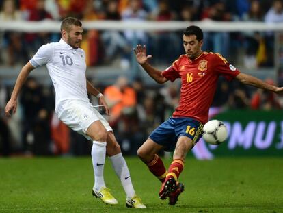 Busquets intenta arrebatar el balón a Benzema.