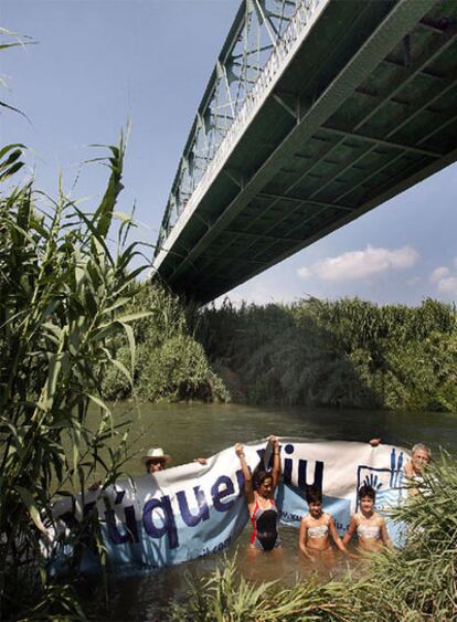 Miembros de Xúquer Viu, ayer, en el puente de Gavarda, abogan por mejorar la calidad del agua.