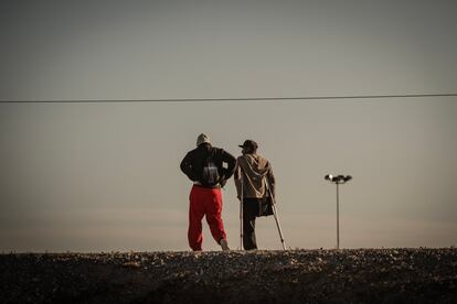 Dos migrantes cerca del río Bravo, esperan para entregarse a la Patrulla Fronteriza de El Paso, el 29 de marzo.