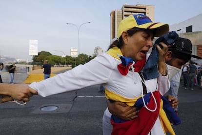 Una opositora al régimen de Maduro sufre los efectos del gas lacrimógeno lanzado por las Fuerzas Armadas, este martes en Caracas.