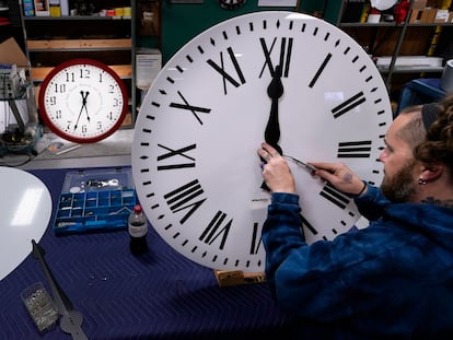 Ian Roders ajusta las manecillas de un reloj en un taller en Medfield, (Massachusetts).