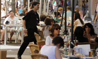 Un camarero trabaja en una terraza de verano.